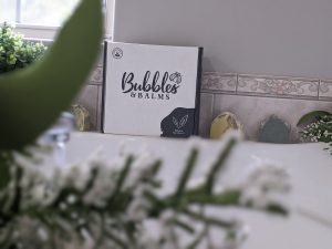 Une boîte Bubbles & Balms se trouve sur un comptoir à côté de pains de savon