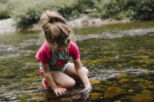 A young girl playing in a creek