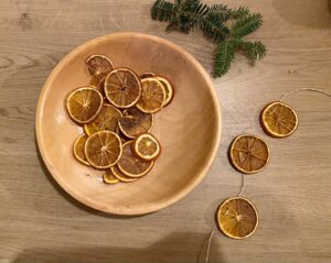 Dehydrated orange slices being strung on twine