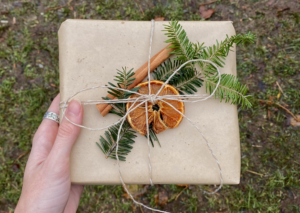 Cadeau de Noël emballé dans du papier avec de la ficelle et une tranche d’orange 