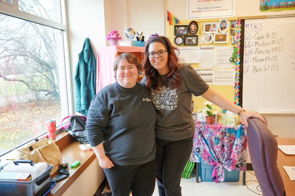 A member of the Gaia team standing with a teacher in a classroom 