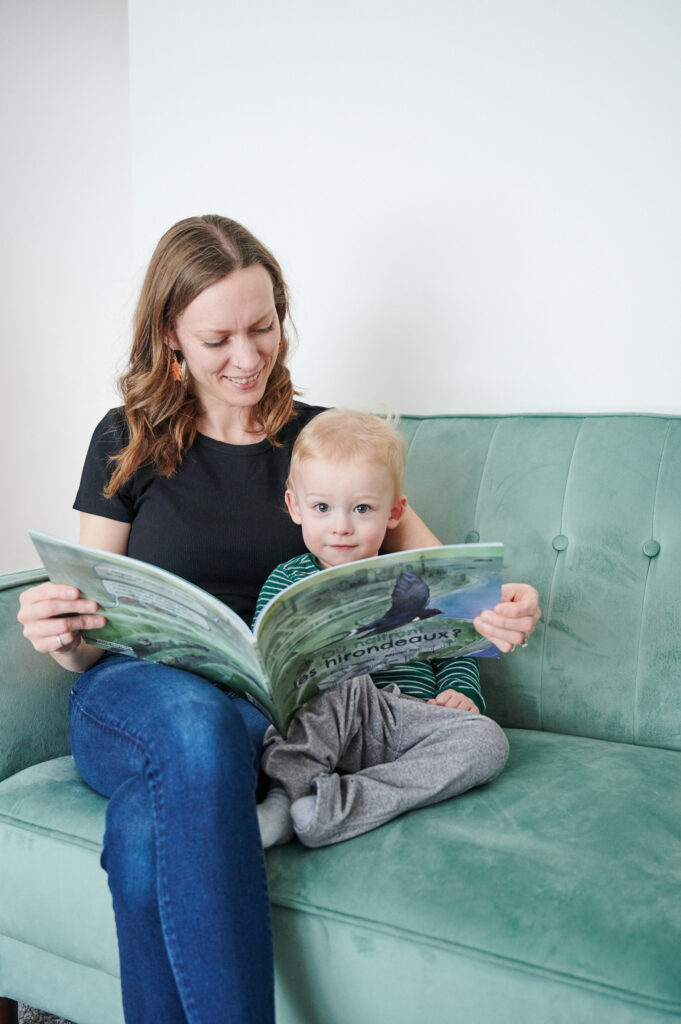 Une mère lit l'album Où naitront les hirondeaux? à son enfant 