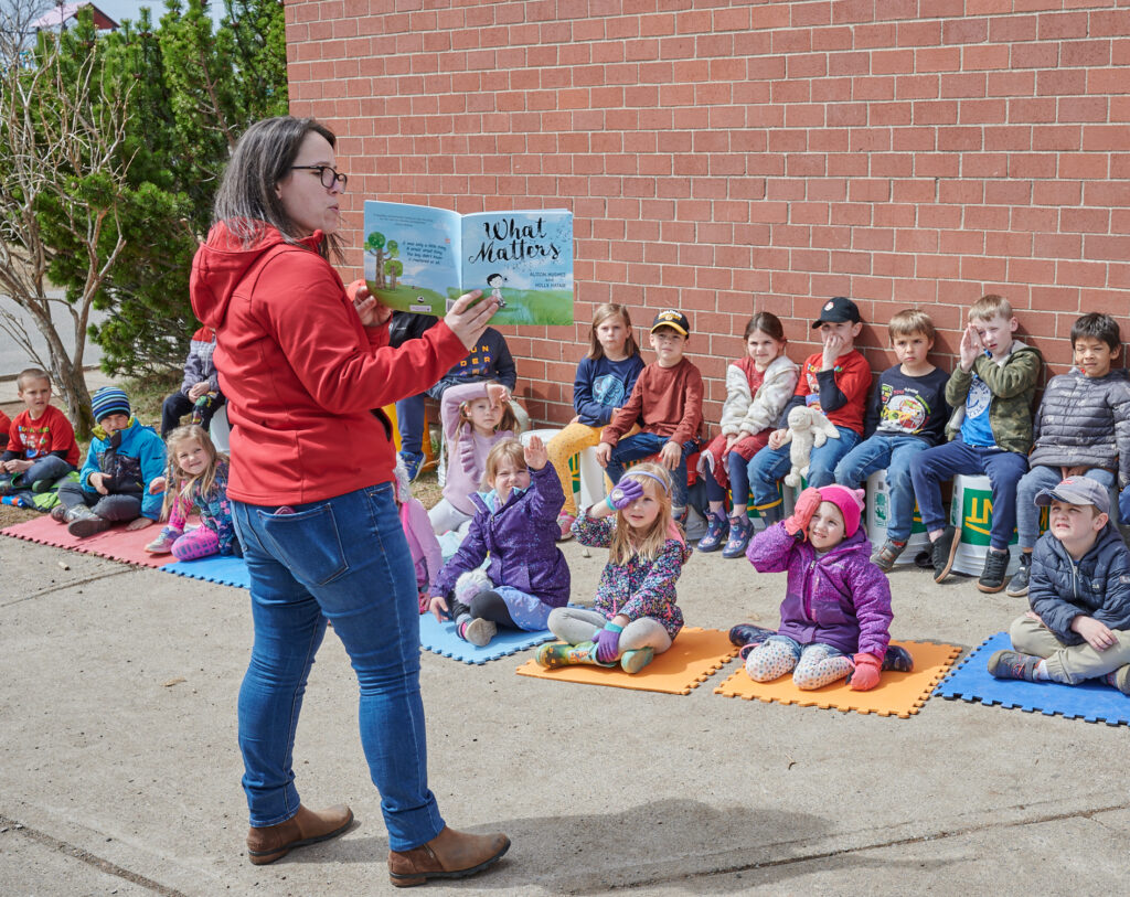 Guylaine reads a story to a group of children