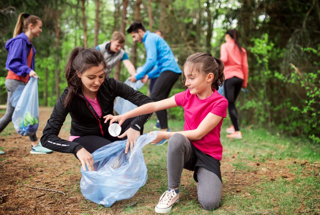 Une mère et sa fille ramassent des déchets à l’extérieur 