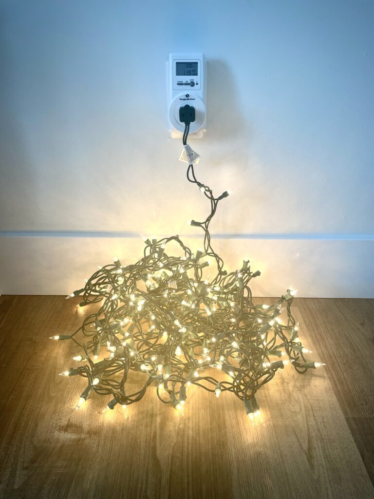Christmas lights plugged into an energy meter 