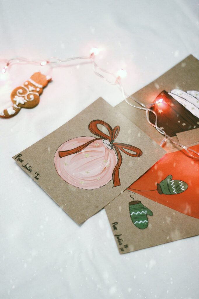 A pile of handmade holiday cards that include drawing of Christmas ornaments and mittens 