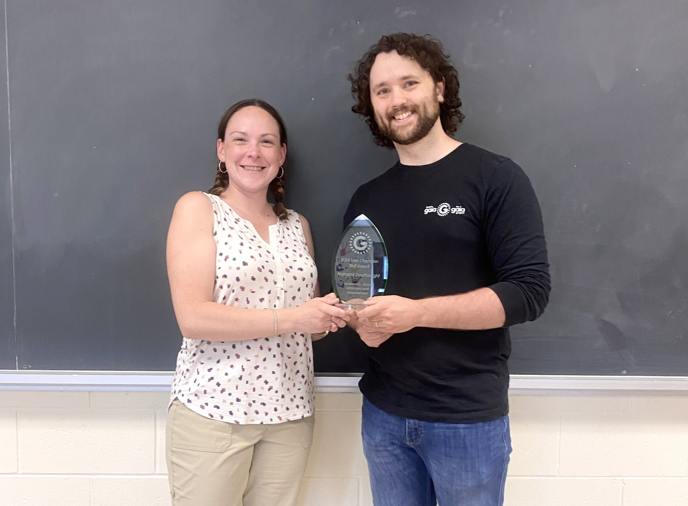 Natasha, holding her award, poses with a Gaia Project staff