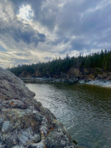 Photo d’une rivière bordée d’une berge rocheuse 