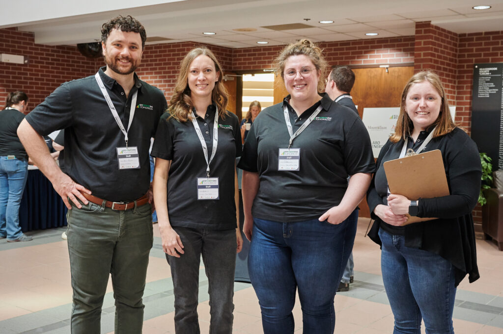 Four staff from The Gaia Project post for a photo at Empowering Tomorrow 