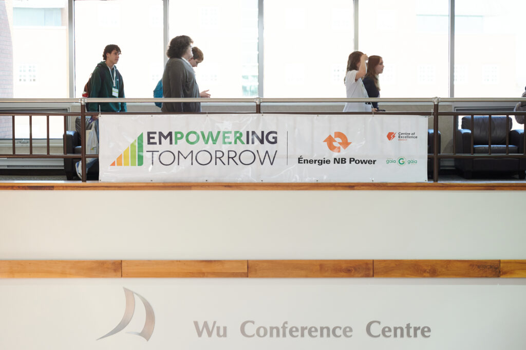 Students walk past a large event banner at Empowering Tomorrow 2025 
