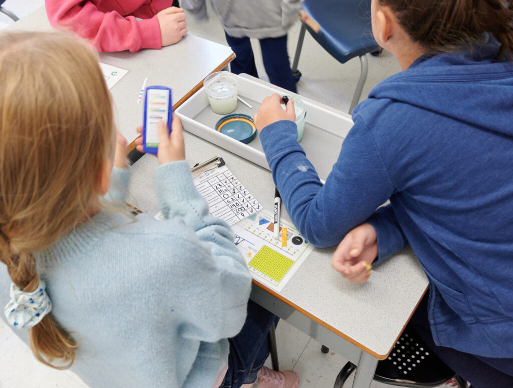 Students using water testing materials to measure pollutants