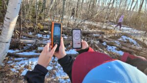 A photo of two students holding air quality monitors outside