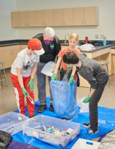 Un enseignant et quatre élèves trient des déchets dans leur classe